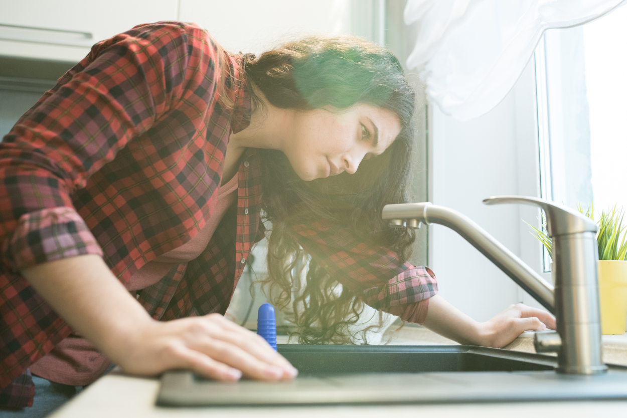 Woman inspecting her sink for mold