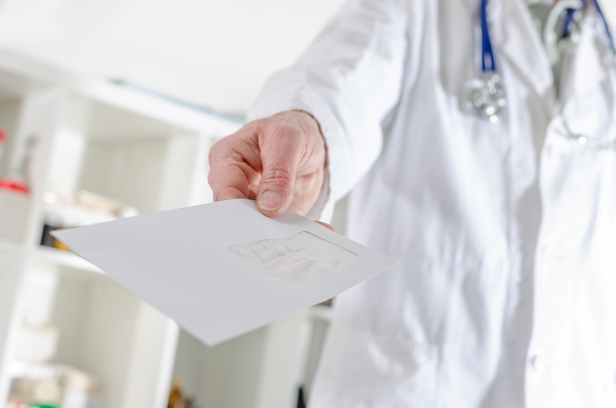 Doctor in white lab coat holding out a letter of medical necessity