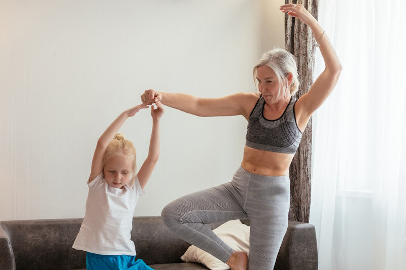 A fit grandmother and granddaughter dancing in the living room