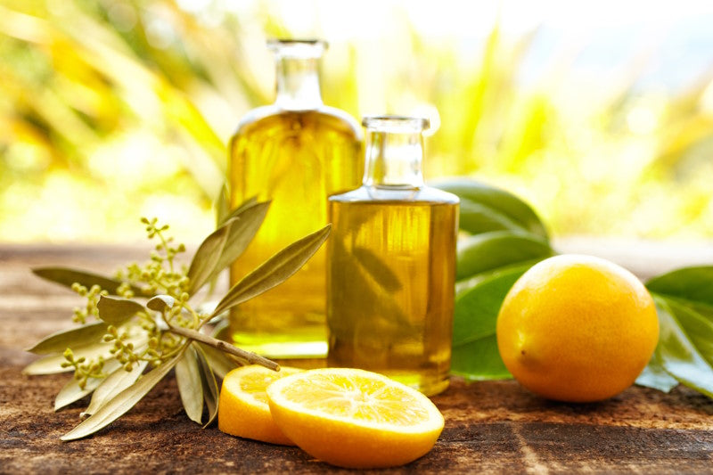 Bottles of olive oil next to sliced lemons