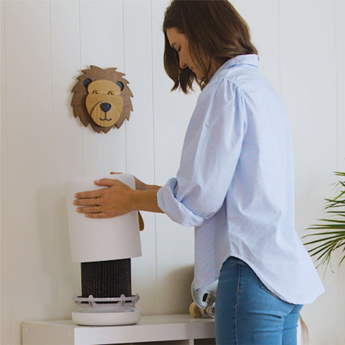 Woman removing the top of Air Mini+ air purifier to change filter.