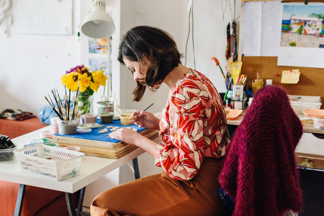 Woman painting a craft at a table