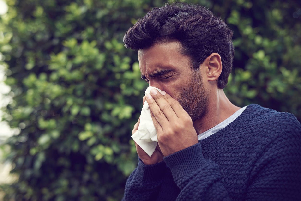 Man sneezing into a tissue