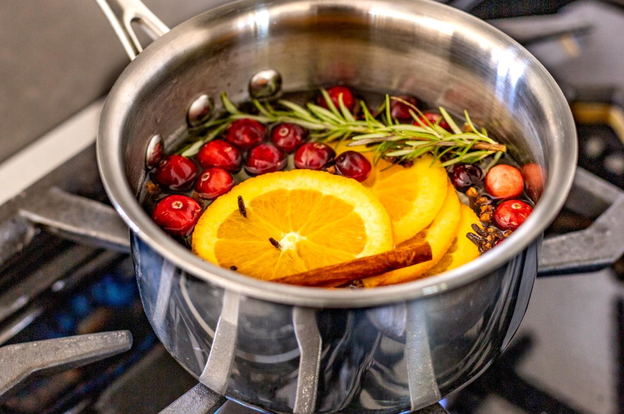 Pot simmering with lemons, cranberries, and rosemary