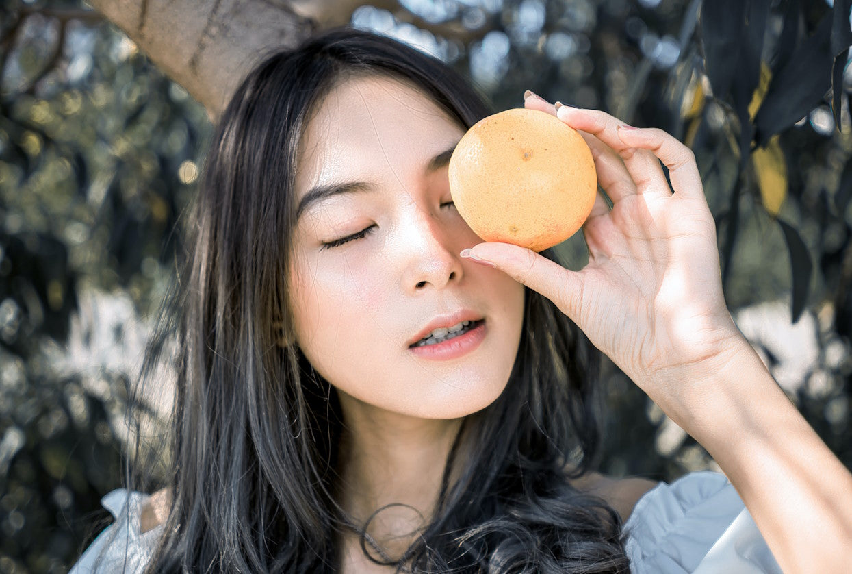 Woman holding up an orange